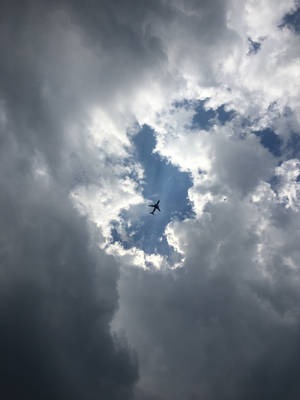 Airplane In Between Clouds Wallpaper