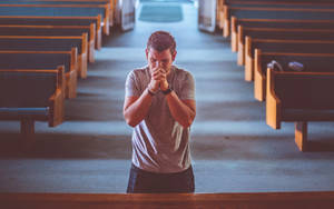 Man Praying Alone In Church Wallpaper