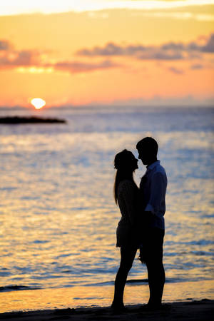 Romantic Beach Couple Chest To Chest At Sunet Wallpaper