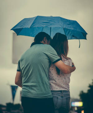 Romantic Couple Kiss Under An Umbrella Wallpaper