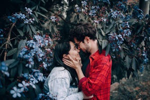 Romantic Couple Touching Noses In Garden Wallpaper
