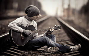 Teenage Boy Standing Alone On A Railway Track Wallpaper