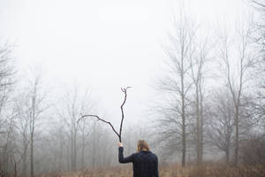 Woman With Branch In Foggy Forest Wallpaper