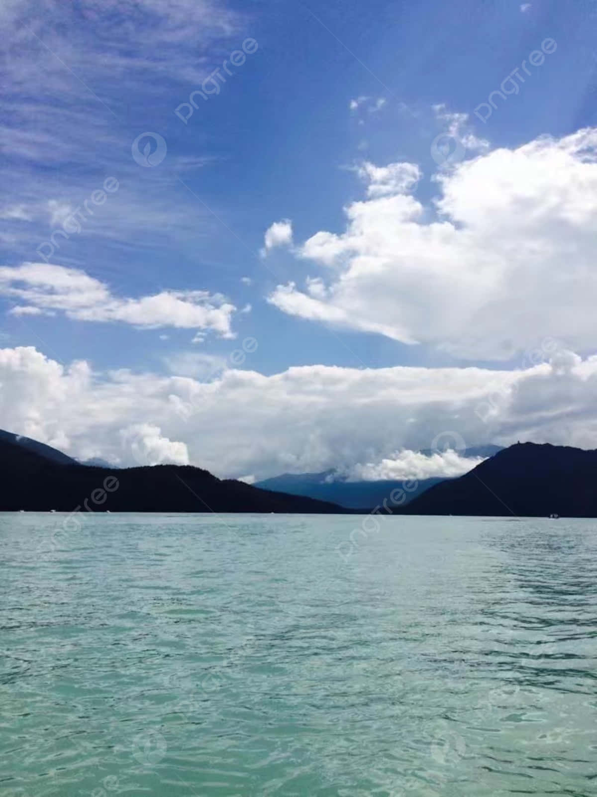 A Lake With Mountains And Clouds In The Background