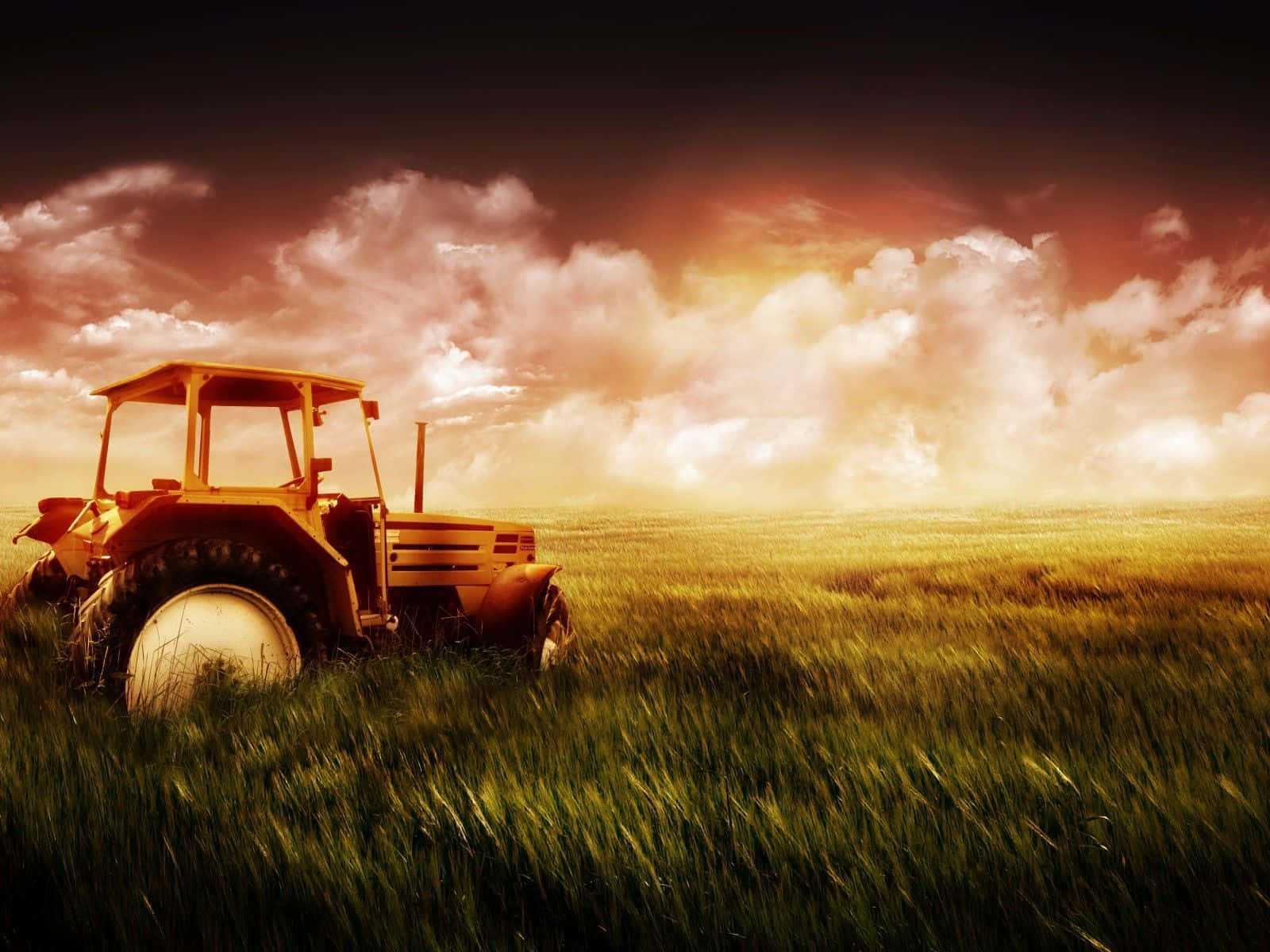 A Tractor In A Field With A Sunset Behind It