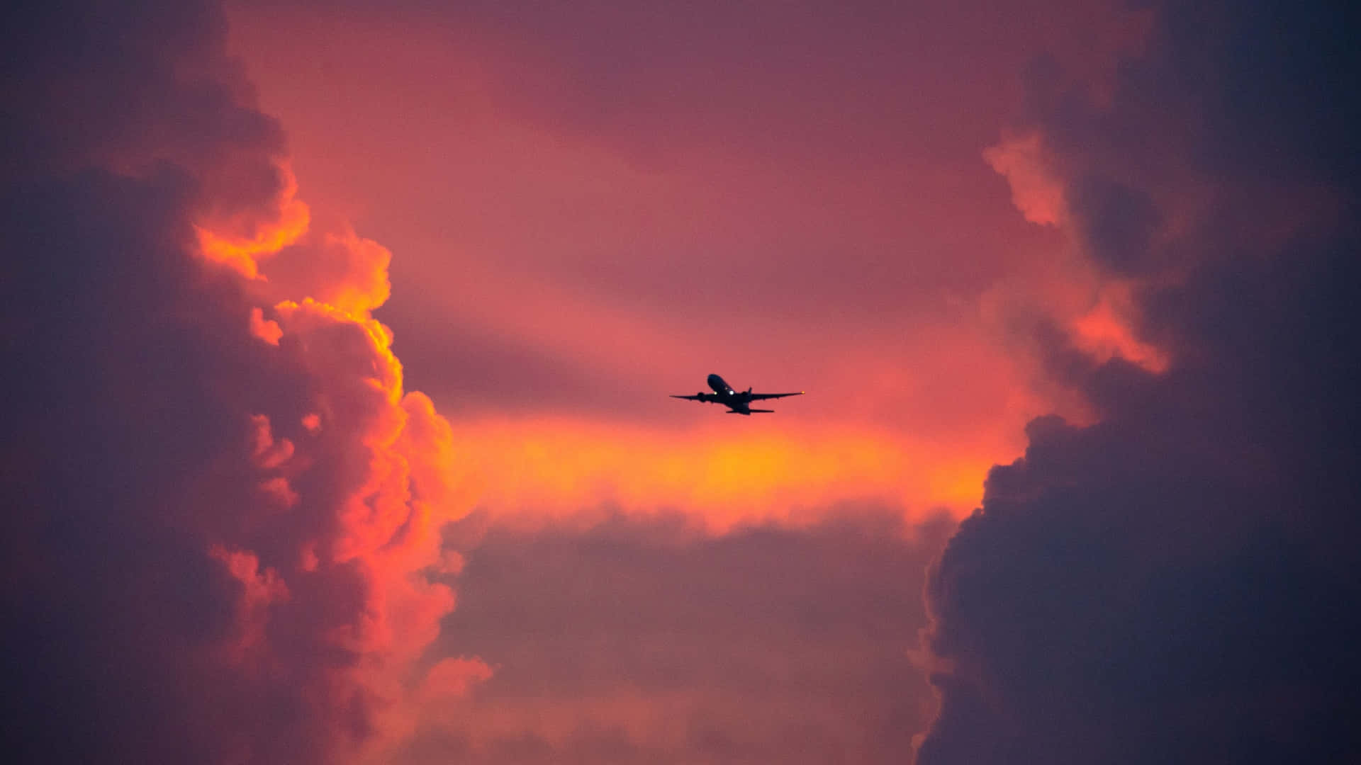 Gliding In The Sky With A Sleek And Vibrant Pink Plane
