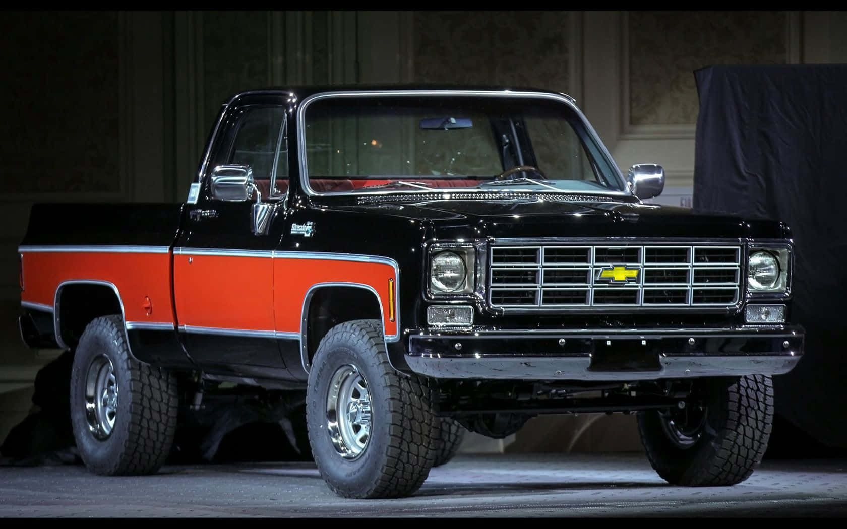 A Black And Orange Pickup Truck Is On Display Wallpaper