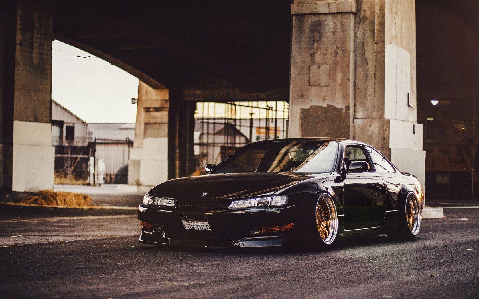 A Black Car Parked Under An Overpass Wallpaper