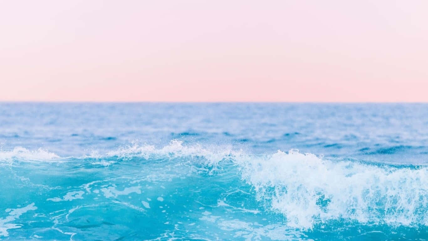 A Blue And Pink Ocean With Waves Crashing Wallpaper