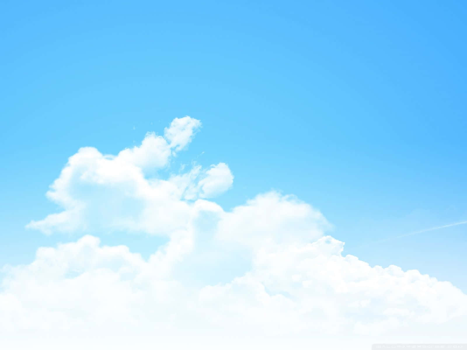 A Blue Sky With Clouds And A Plane Flying Over It Wallpaper