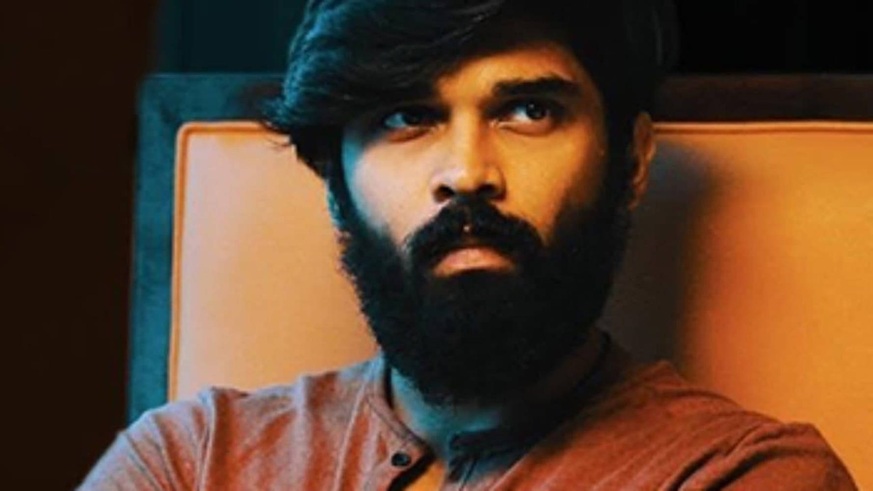A Captivating Still Of Adithya Varma Sporting His Signature Beard Wallpaper