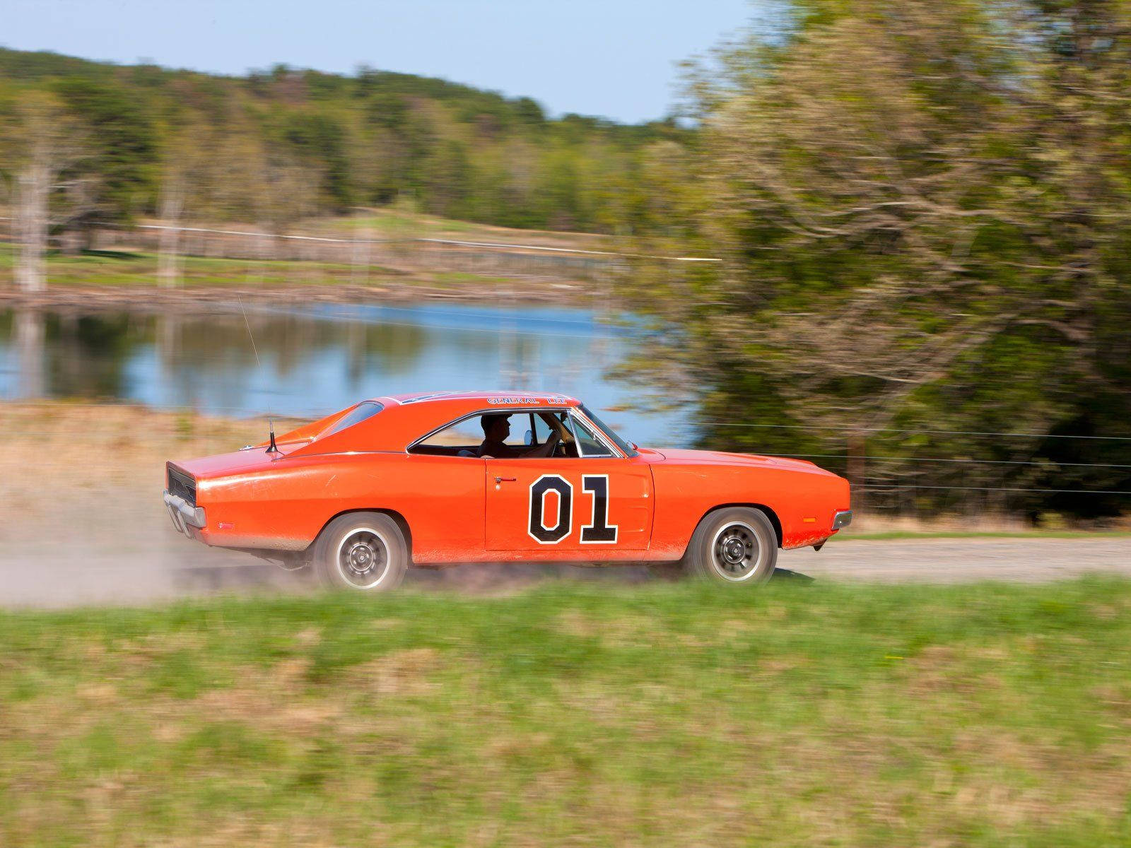 A Car Driving Down A Dirt Road Wallpaper