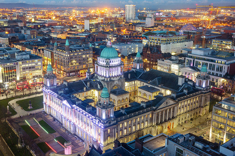 A City At Night With A Large Building Wallpaper