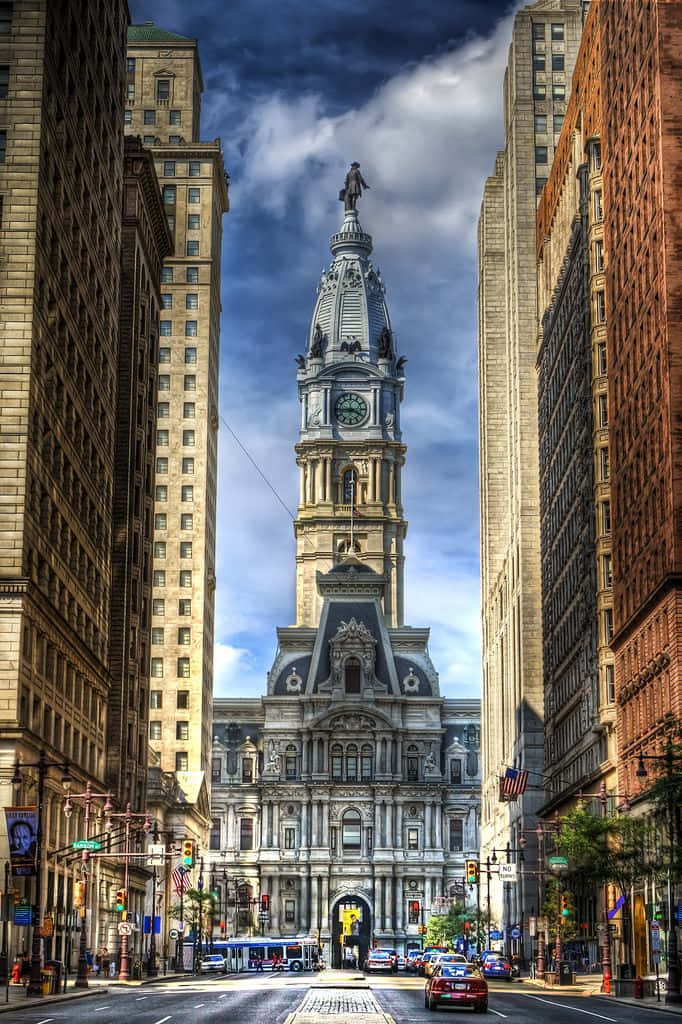 A City Street With Tall Buildings And A Clock Tower Wallpaper