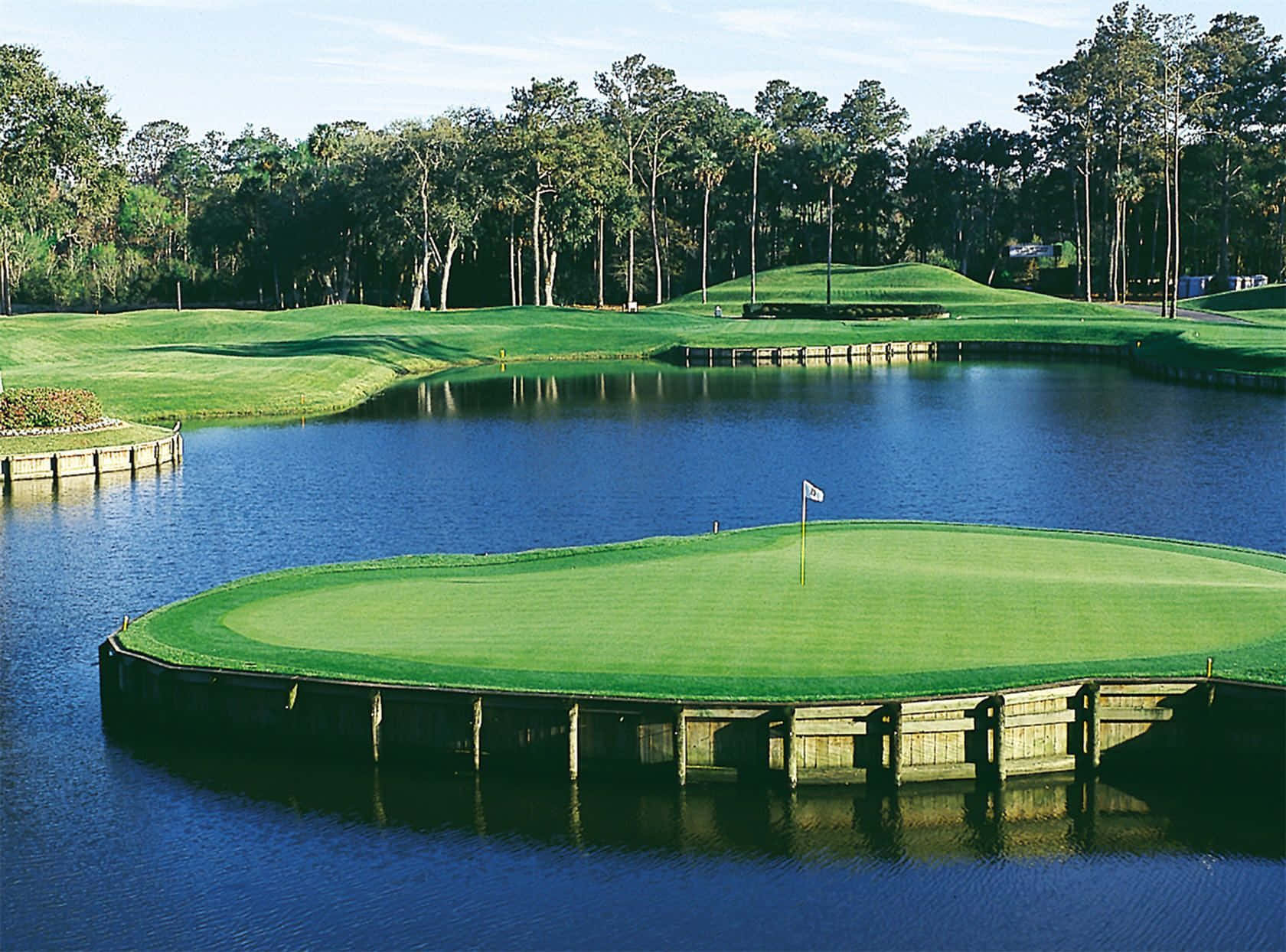 A Golf Course With A Lake And A Green Wallpaper