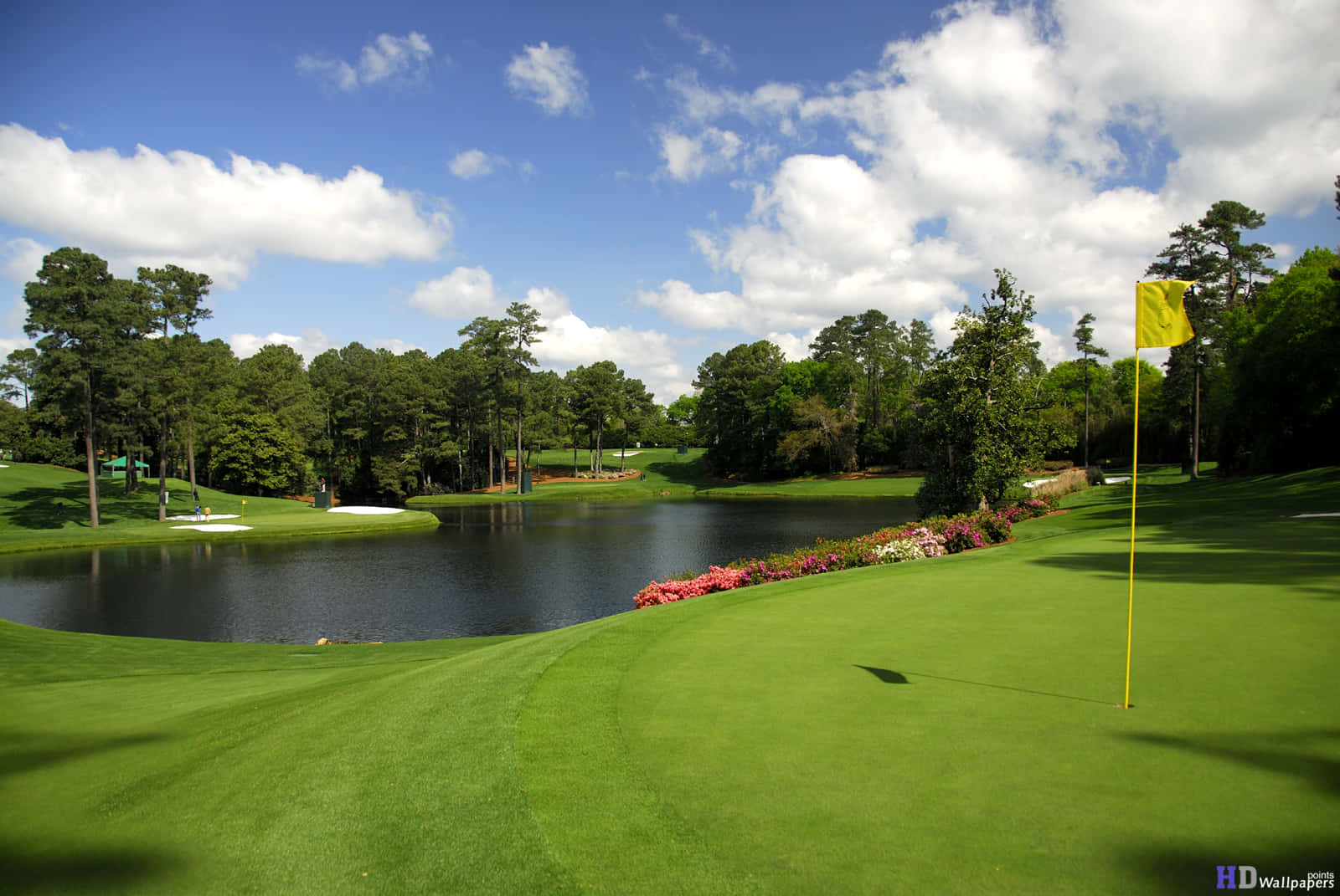 A Golf Course With A Pond And Trees Wallpaper