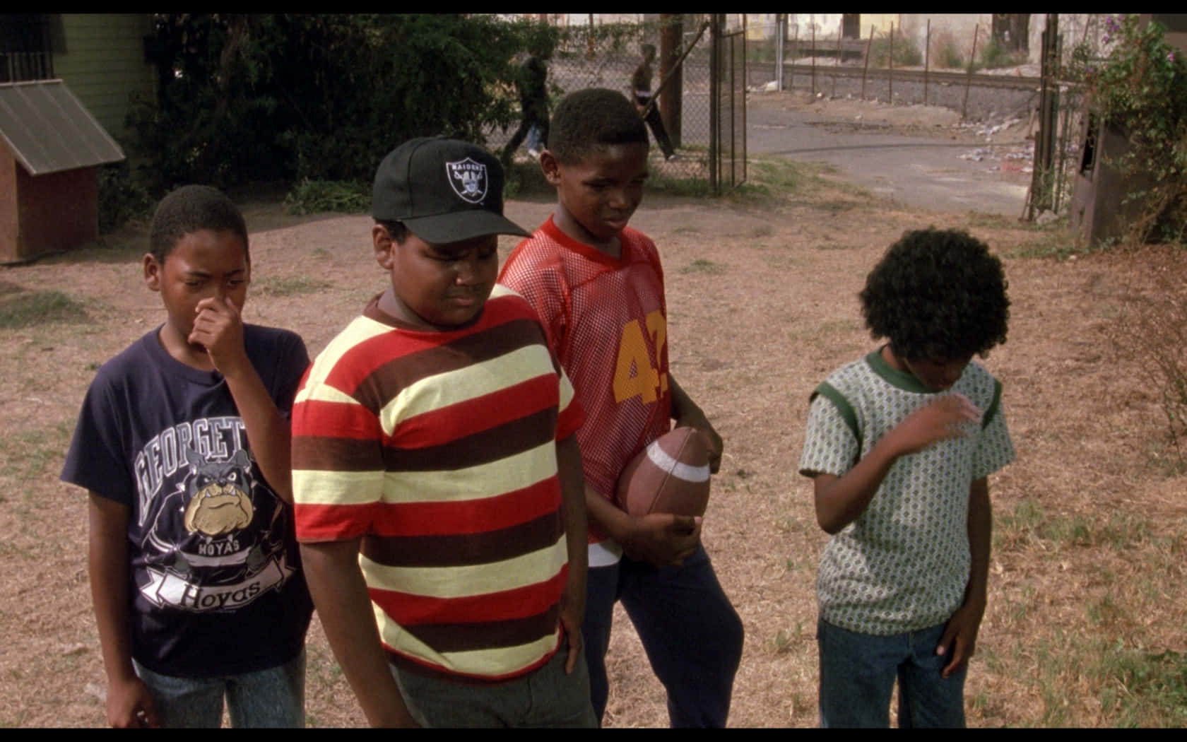 A Group Of Boys Standing In A Field With A Football Wallpaper