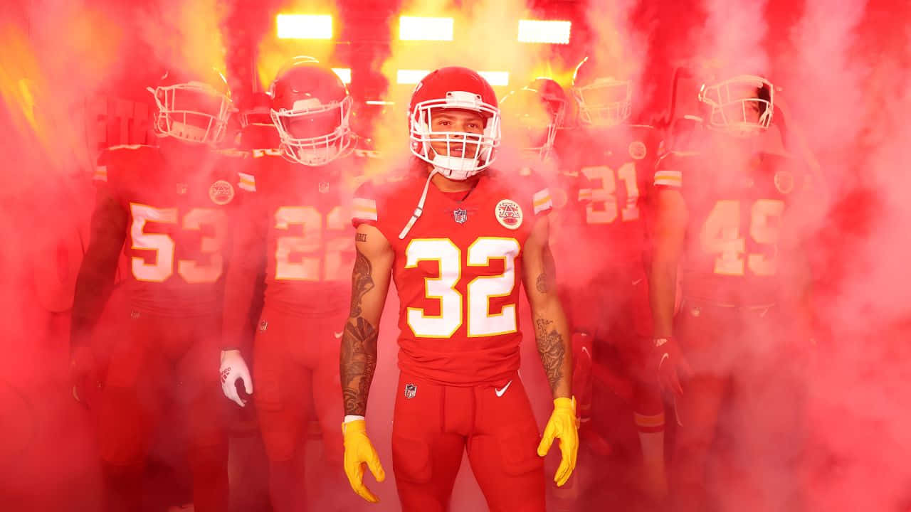 A Group Of Kansas Chiefs Players Standing In Front Of Smoke Wallpaper