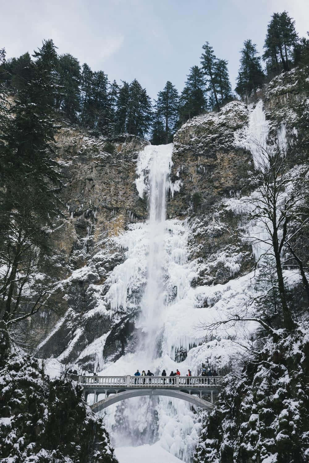 A Group Of People Standing Near A Waterfall Wallpaper