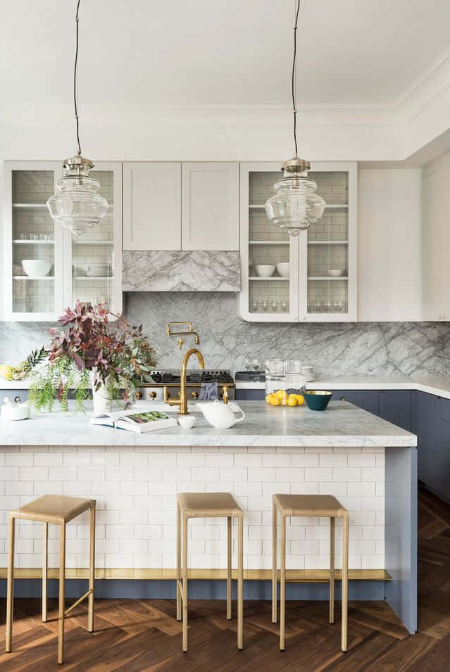 A Kitchen With Marble Counter Tops And Wooden Floors Wallpaper