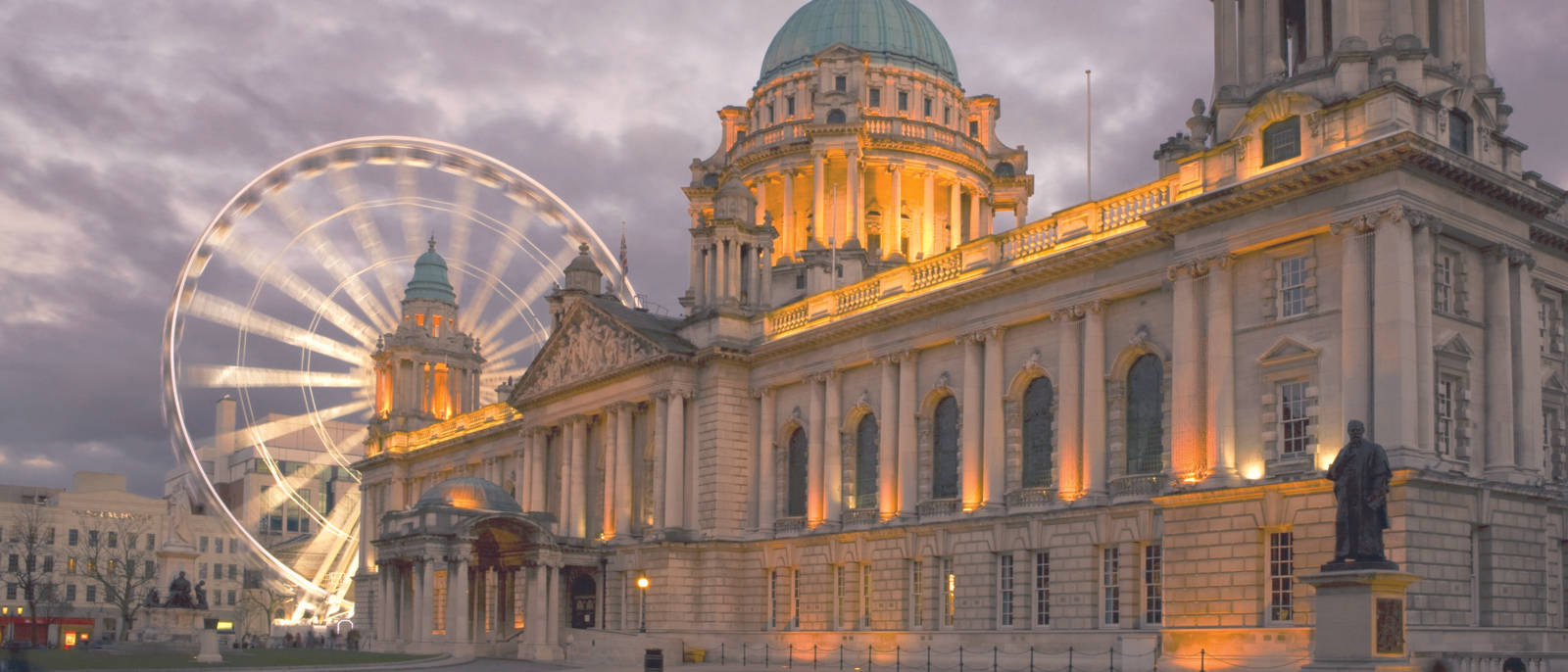 A Large Building With A Ferris Wheel In Front Of It Wallpaper