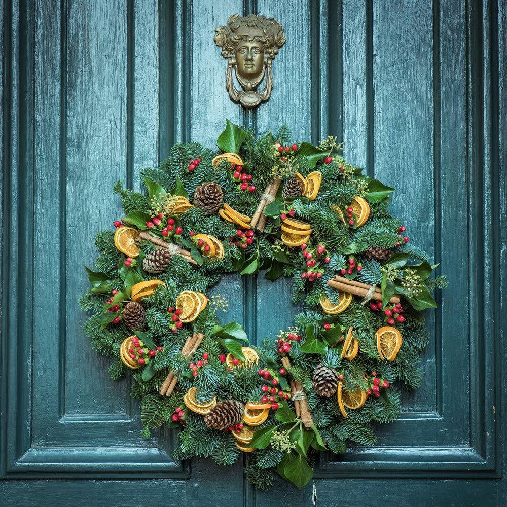 A Lovely Christmas Wreath Garnished With Zesty Orange Slices Wallpaper