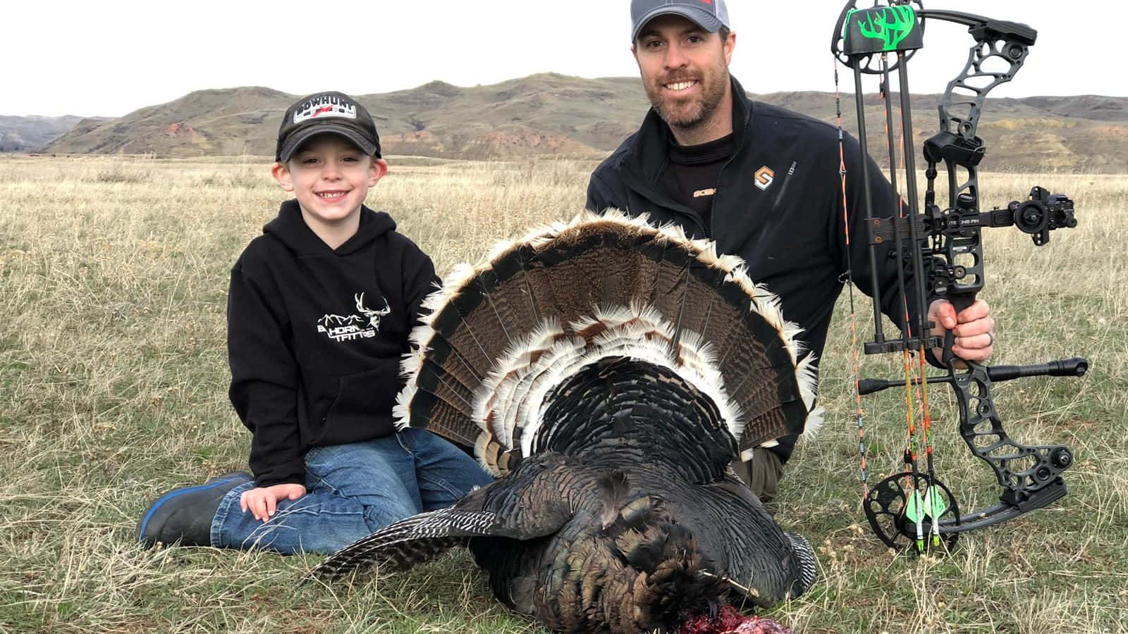 A Man And A Boy Pose With A Turkey Wallpaper