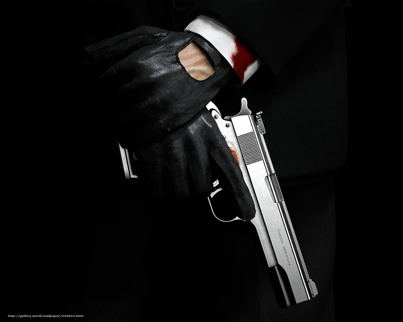 A Man In A Suit Holding A Gun Wallpaper