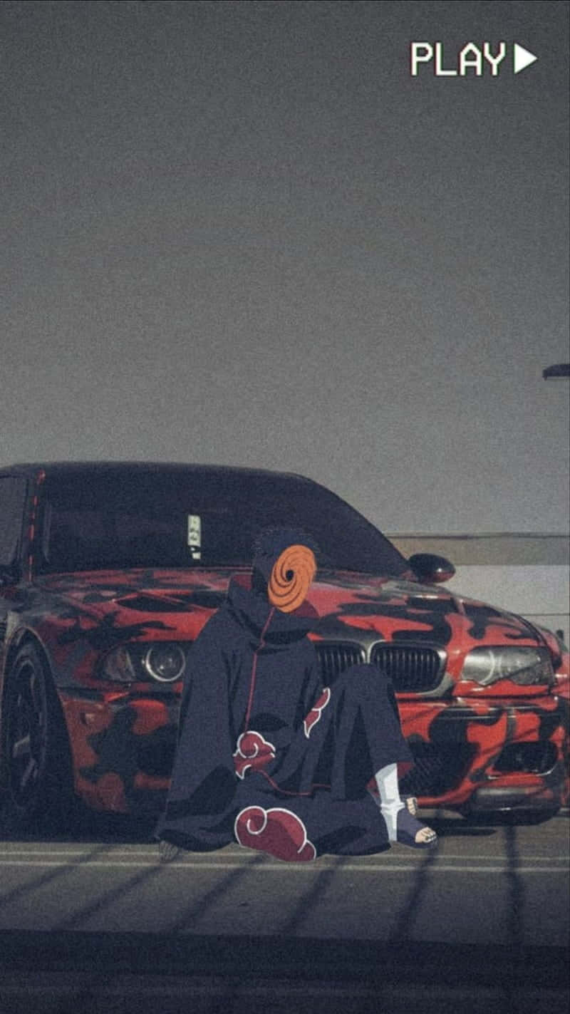 A Man Is Sitting On The Ground Next To A Red Car Wallpaper