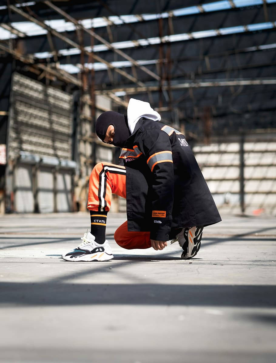 A Man Kneeling Down In An Industrial Building Wallpaper