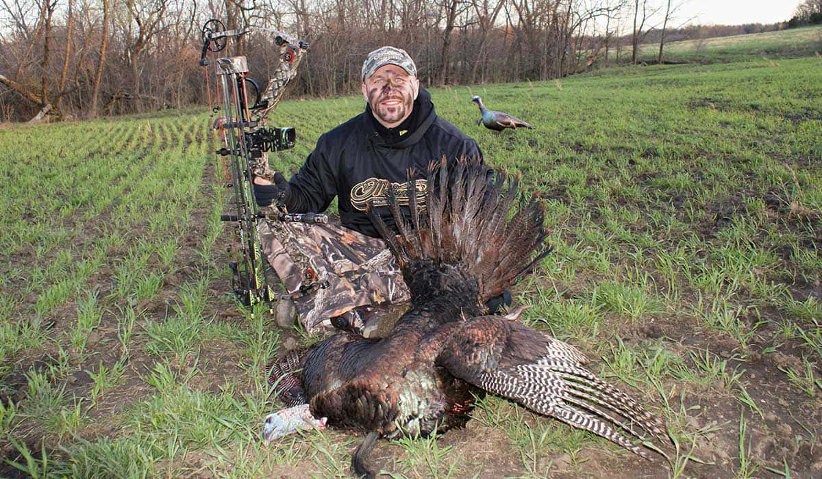 A Man Posing With A Turkey In The Field Wallpaper