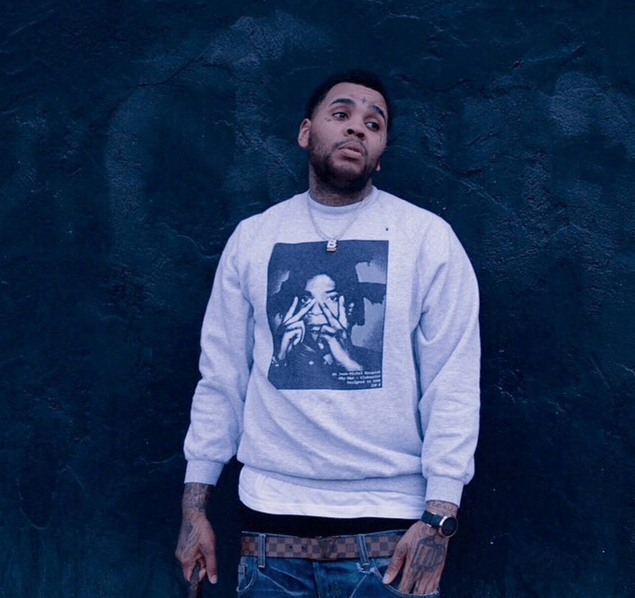 A Man Wearing A Grey Sweatshirt With A Picture Of A Man Wallpaper