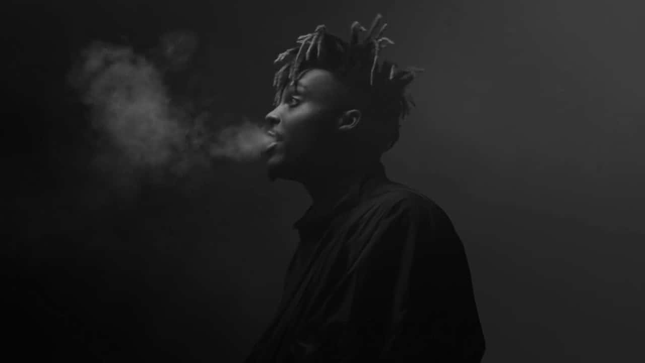 A Man With Dreadlocks Smoking In The Dark Wallpaper