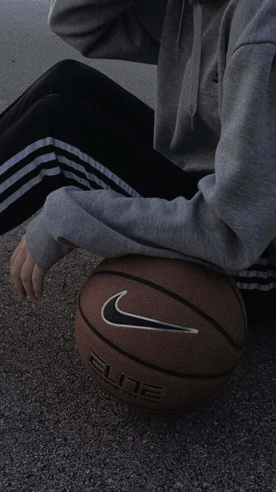 A Person Sitting On The Ground With A Basketball Ball Wallpaper