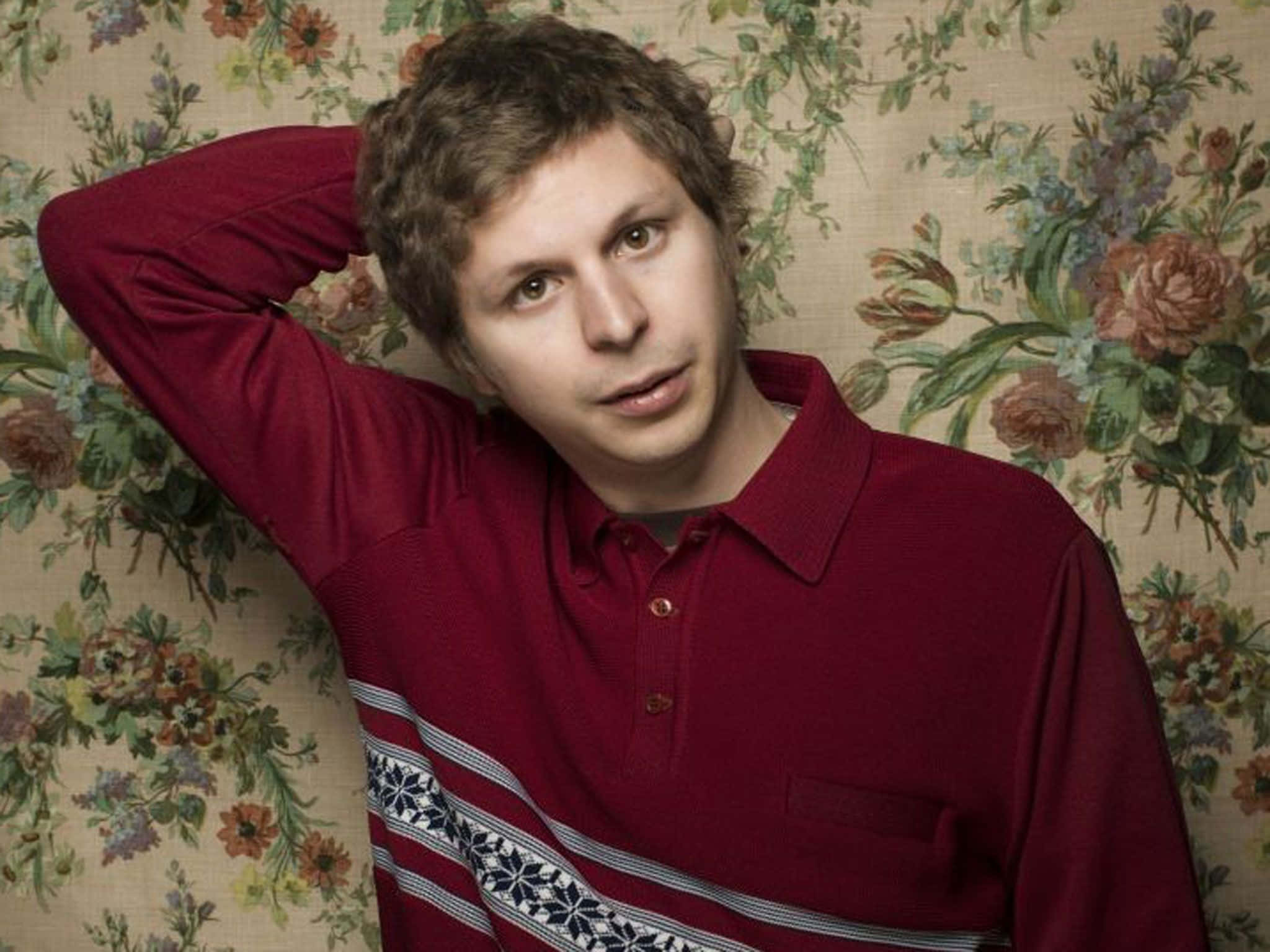 A Smiling Michael Cera Amid A Colorful, Abstract Background. Wallpaper