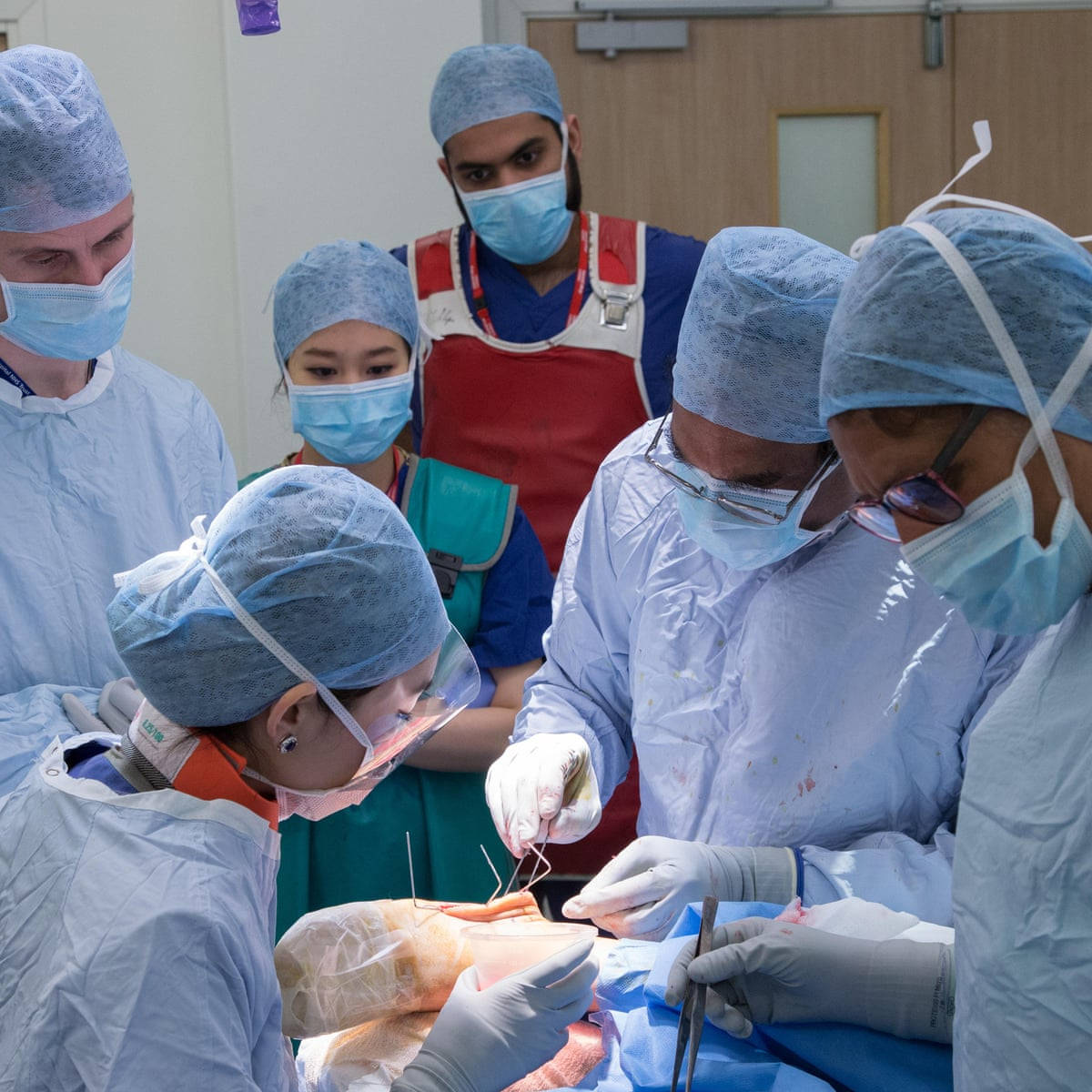 A Surgeon Performing Surgery In Operating Theatre Wallpaper