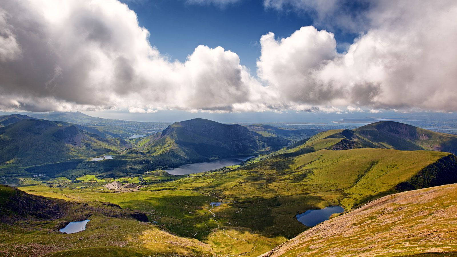 A View Of A Mountain Range With Clouds In The Sky Wallpaper