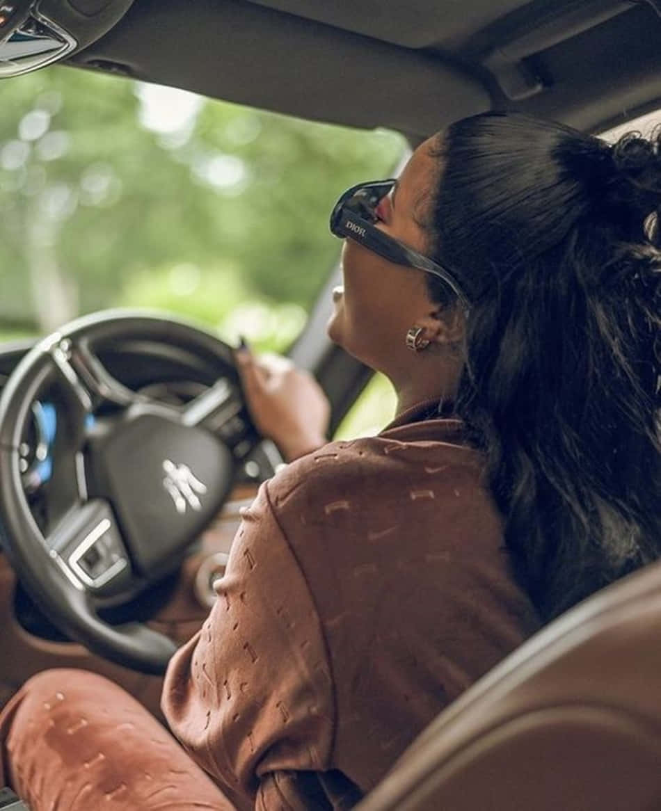 A Woman Driving A Car With Sunglasses On Wallpaper