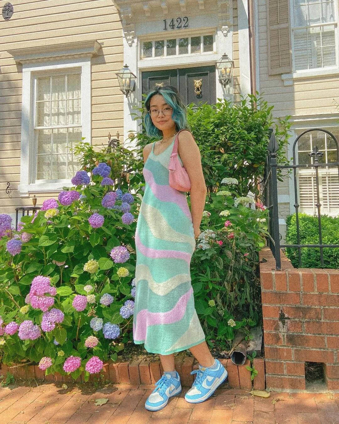 A Woman In A Dress Standing In Front Of A House Wallpaper