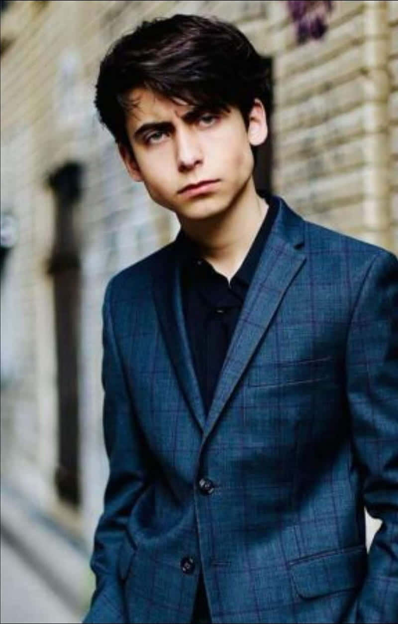 A Young Man In A Suit Is Posing For A Picture Wallpaper