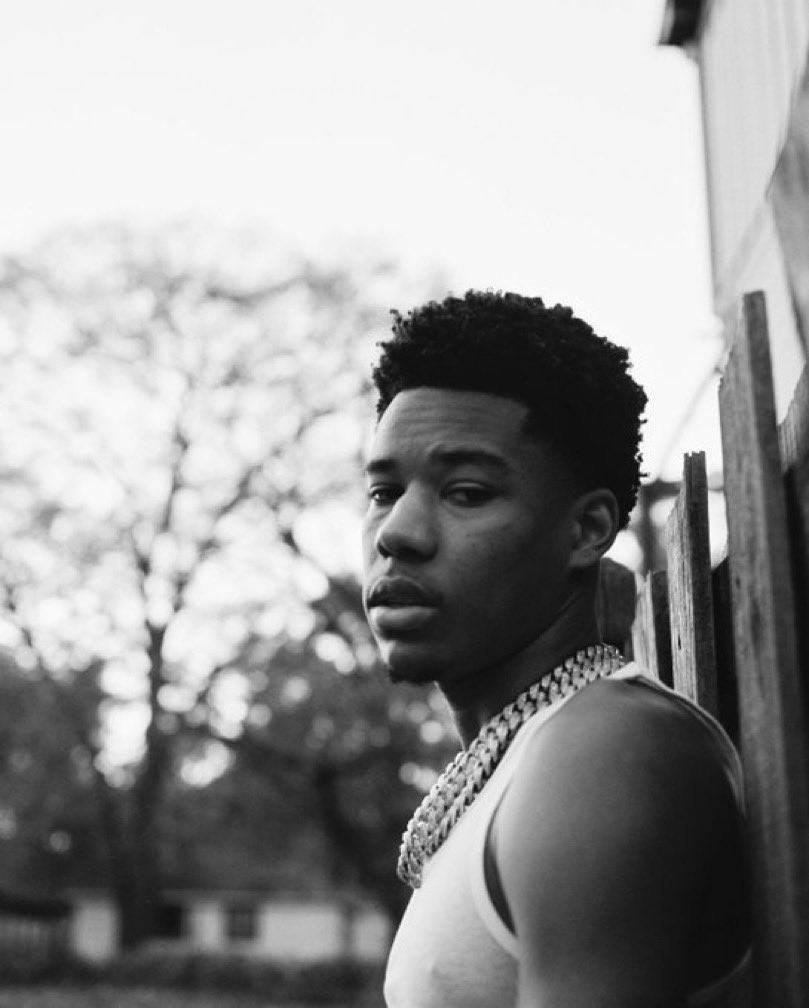 A Young Man Leaning Against A Fence Wallpaper