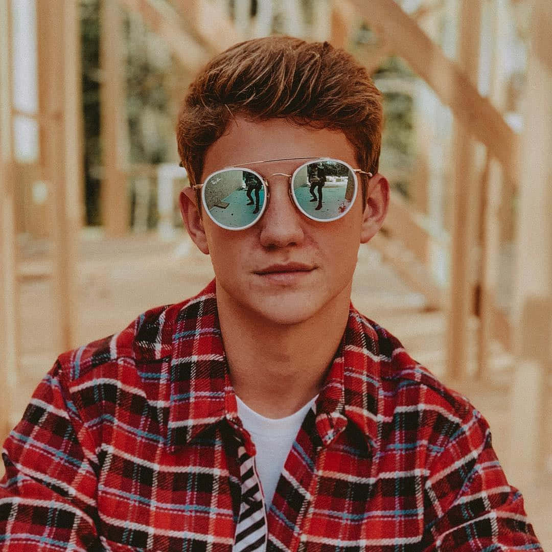 A Young Man Wearing Sunglasses And A Plaid Shirt Wallpaper