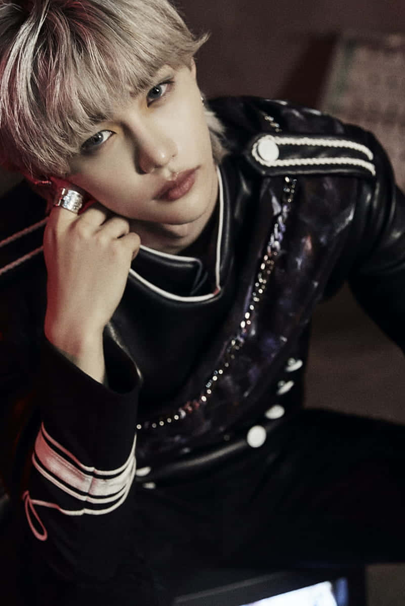 A Young Man With Grey Hair Sitting On A Chair Wallpaper