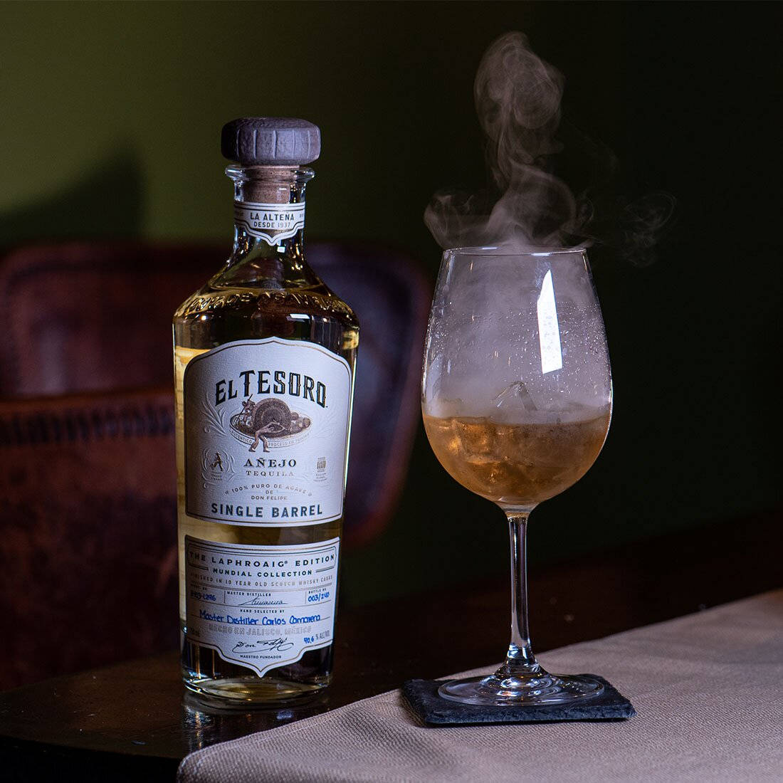 An Exquisite Bottle Of El Tesoro Tequila Showing Its Sophisticated Charm In A Smoky Ambiance. Wallpaper