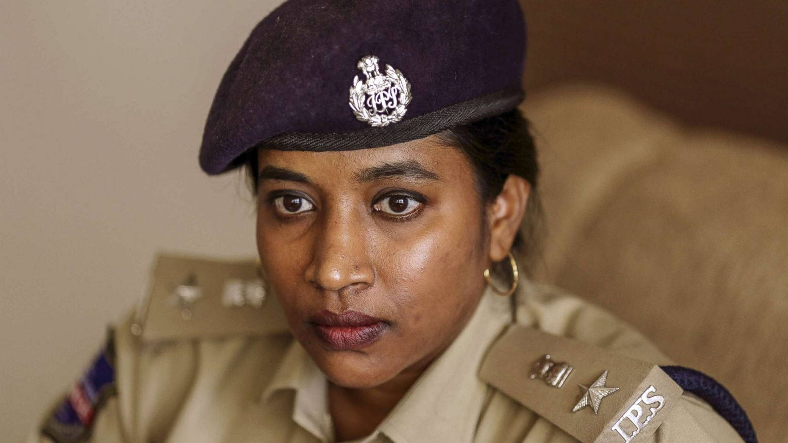 An Image Of A Female Officer Wearing A Cap With An Ips Logo. Wallpaper