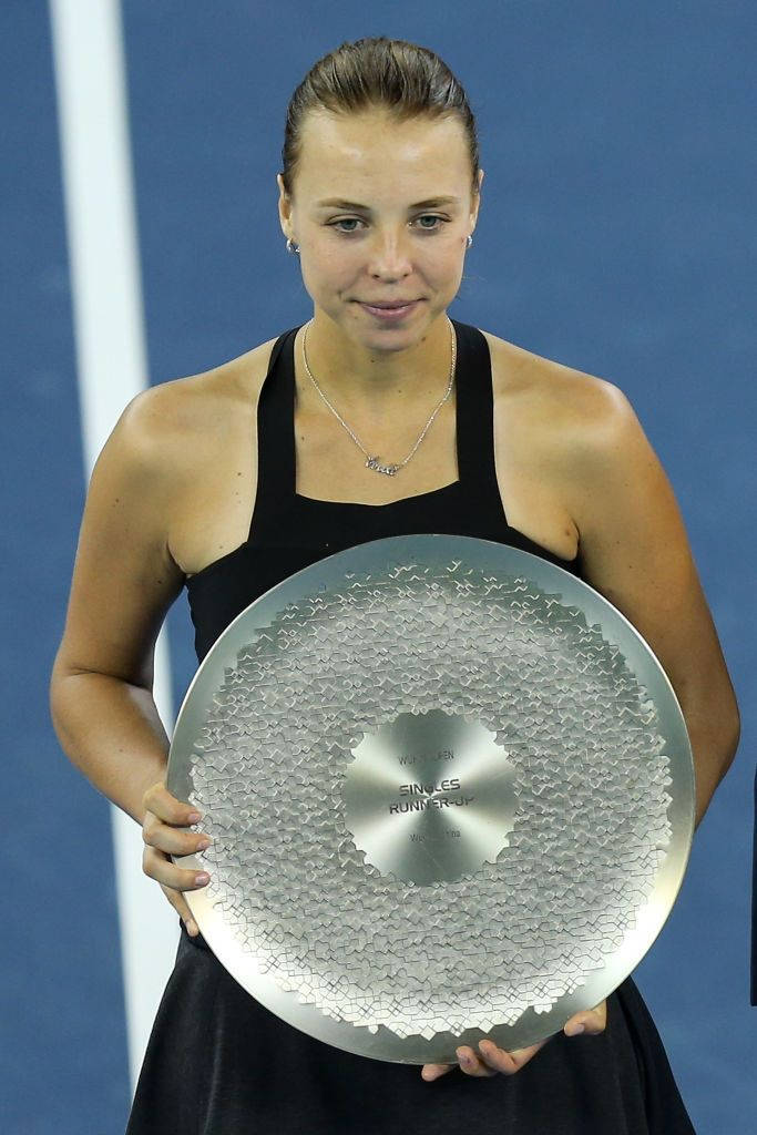 Anett Kontaveit Proudly Holding Up Her Championship Trophy Wallpaper