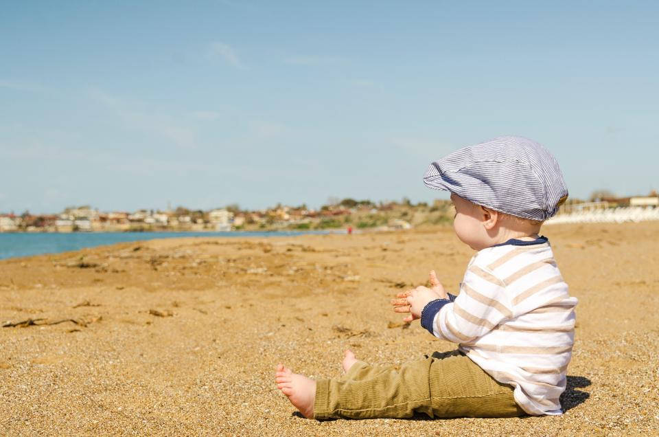 Baby Boy Seated On The Beach Wallpaper