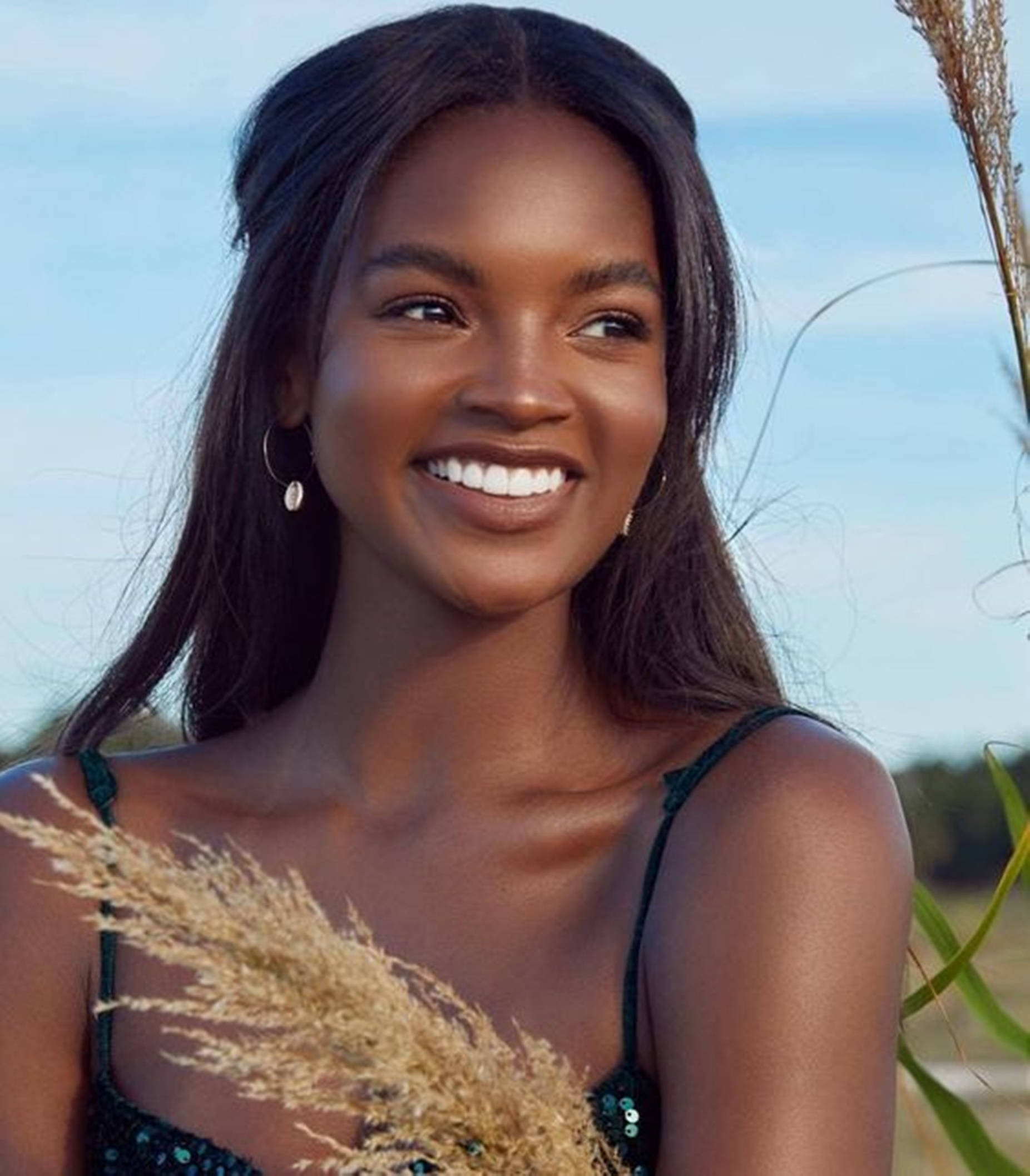 Beautiful Black Woman Posing With A Sprig Of Wheat Wallpaper