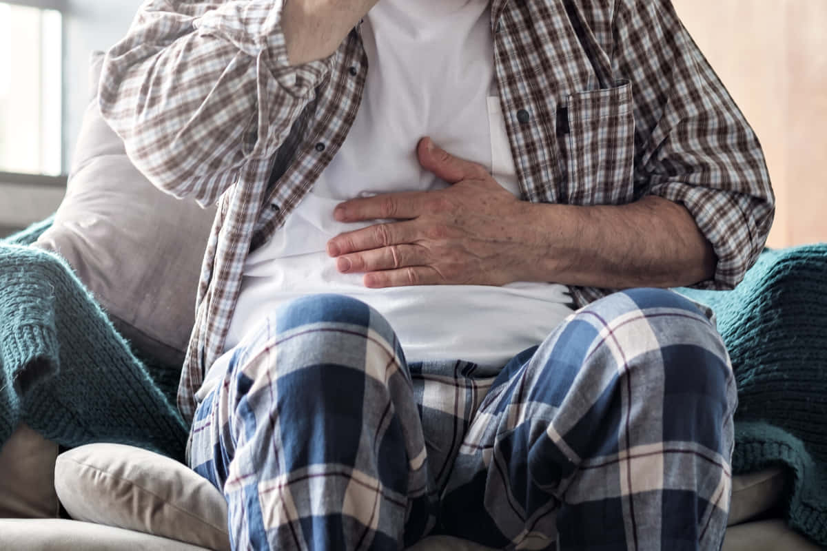 Caption: Ailing Elder Man Struggling With Nausea Wallpaper