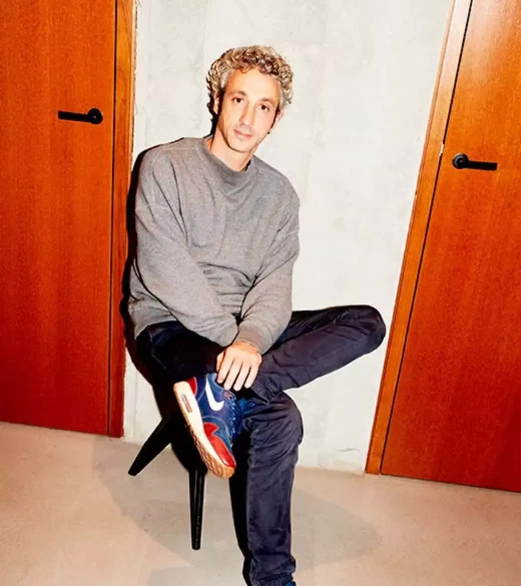 Caption: Jérôme Dreyfuss Posing Thoughtfully On A Chair Wallpaper